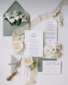 the wedding stationery is laid out with flowers