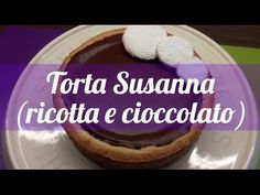 there is a chocolate tart on the plate with purple and white writing that says torta susana ricotta e ciocoato