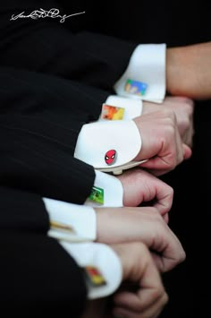 someone is holding onto their wristbands to show off the matching cuff links that they are wearing