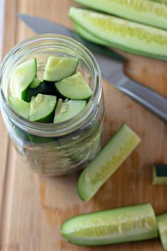 sliced cucumbers in a mason jar on a cutting board