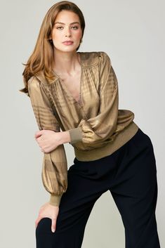 This is the perfect party top thanks to its plunging surplice neckline and subtly striped metallic shimmer. Featuring a gently crinkled texture, the long-sleeve style has a relaxed fit, paneled shoulders, and glittery rib trim. •Surplice neckline •Paneled shoulders •Long sleeves •Relaxed fit •Glitter rib trim at cuffs & hem item number 2230090-1 100% Polyester Elegant Spring Blouse With Shimmer, Chic Shimmer Blouse For Spring, Chic Spring Shimmer Blouse, Gold V-neck Top For Fall, Long Sleeve Shimmer Blouse For Spring, Party V-neck Blouse With Blouson Sleeves, Gold Long Sleeve Tops For Spring, Fall V-neck Blouse With Blouson Sleeves, Gold Long Sleeve Tops For Night Out