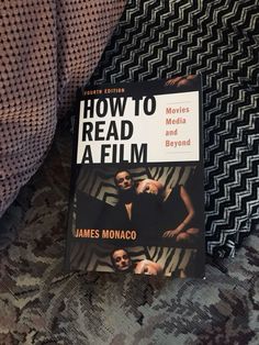 the book how to read a film is sitting on a couch next to some pillows