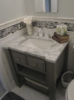 a white sink sitting under a bathroom mirror