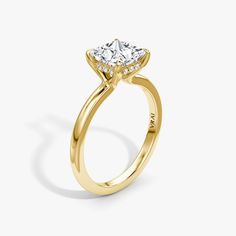 a yellow gold engagement ring with an oval cut diamond in the center and side stones