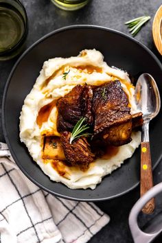 a plate with mashed potatoes, meat and gravy