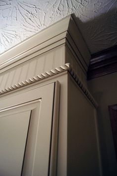 the corner of a kitchen cabinet with molding on it