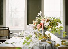 the table is set with flowers and wine glasses