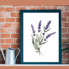 a framed print of lavender flowers on a shelf next to a watering can and brick wall