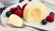 a white plate topped with cheesecake and berries