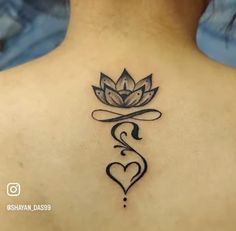 a lotus tattoo on the back of a woman's upper back and neck with a heart