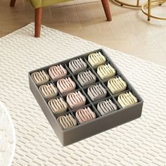 a tray filled with chocolates sitting on top of a white rug next to a green chair