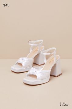 We recommend styling the Lulus Remie White Satin Knotted Platform High Heel Sandals with any look that needs an extra dash of fabulousness! Sleek woven satin shapes these iconic heels that feature a trendy square footbed (atop a 0.75"" toe platform) and gather straps that create a wide, knotted peep-toe upper. A matching quarter strap secures around ankle with a gold buckle, all atop a chunky block heel. 3. 5" wrapped block heel. Lightly cushioned insole. Felted rubber sole has nonskid markings. Man Made Materials. Imported. Lulus | Remie White Satin Knotted Platform High Heel Sandal Heels. Satin Heels With Wrapped Heel For Spring, Spring Satin Heels With Wrapped Heel, Spring Satin High Heels, Satin Sandals With Wrapped Heel And Open Heel, Satin Sandals With Wrapped Heel And Open Design, Satin Sandals With Wrapped Heel And Open Back, Satin Sandals With Wrapped Heel, Spring Satin Heels With Block Heel, Spring Satin Block Heel Shoes