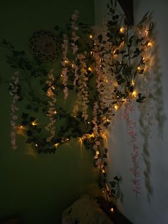 a teddy bear sitting next to a wall covered in flowers and vines with fairy lights