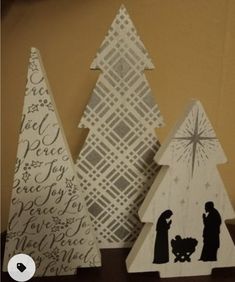 three wooden christmas trees on a table