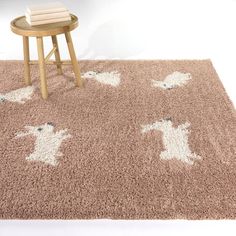 a brown rug with white dogs on it next to a small table and stools