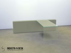 a glass table sitting on top of a cement floor next to a white wall in an empty room