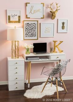 a white desk topped with a laptop computer next to a wall covered in framed pictures