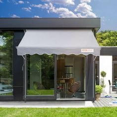 an open patio with a table and chairs under a white awning on the outside