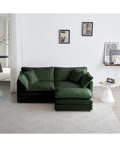 a living room with a large green couch and white rugs on the floor in front of it