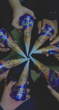 several people holding up their hands in the shape of a star with blue and gold foil