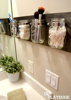 the bathroom is decorated with mason jars and toothbrushes on the shelf above the sink