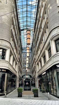 the inside of a building with many windows and planters on either side of it