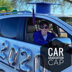 a woman sitting in the driver's seat of a car with graduation cap on