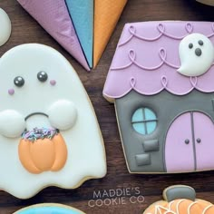 decorated cookies are displayed on a table with other items in the shape of house and ghost