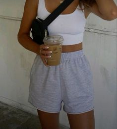 a woman taking a selfie with her cell phone and holding a cup of coffee