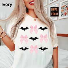 Comfort Colors® Halloween Shirt -- Pink Bows + Bats Fall Shirt Gift yourself or someone special with our cute Comfort Colors® Halloween Shirt featuring sweet pink bows and spooky bats! Head on over to Gifts on the Side for more Halloween t-shirts:  https://giftsontheside.etsy.com SIZING *This is a unisex sized t-shirt.  *Please read the sizing guide carefully to ensure correct sizing.  *Measuring a favorite t-shirt will help you find the correct size.  FABRICATION -100% combed and ring-spun cott Bat Shirt, Shopping Gifts, Halloween T Shirts, Bow Shirts, Pink Bows, Fall Tee, Women Pink, Cute Aesthetic, Fall Shirt