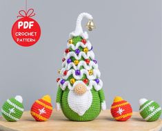 a crocheted christmas ornament sitting on top of a wooden table next to ornaments