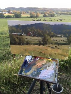 an easel sitting on top of a grass covered field