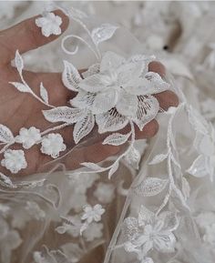 a close up view of the lace and flowers on a wedding dress with sheer fabric