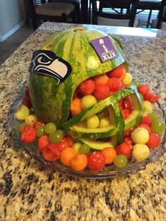 a watermelon helmet made out of fruit on a counter top with the seattle rams logo painted on it