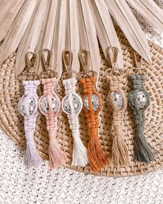 four tasseled keychains are sitting on a woven mat