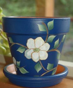 a blue flower pot sitting on top of a wooden table