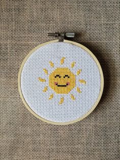 a cross stitch sun with a smile on it's face