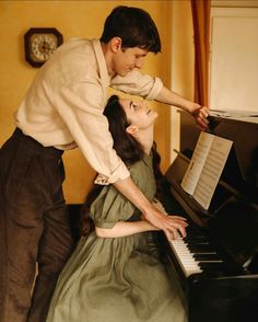 a man standing next to a woman near a piano