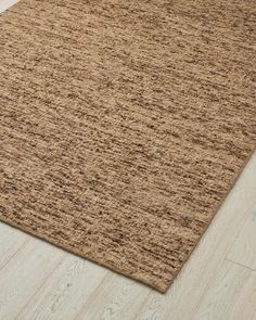 an area rug on the floor with white wood floors and light colored wooden planks