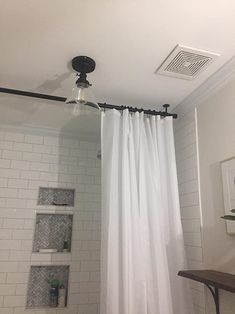 a bathroom with a shower curtain and white tile flooring, along with a toilet in the corner