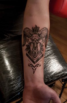 a person's arm with a goat tattoo on it and an arrow in the middle