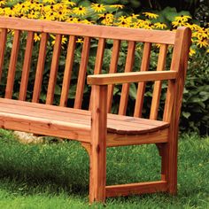 a wooden bench sitting on top of a lush green field next to yellow wildflowers