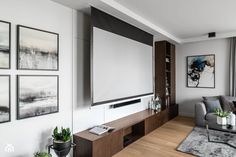 a living room with pictures on the wall and a flat screen tv mounted to the wall