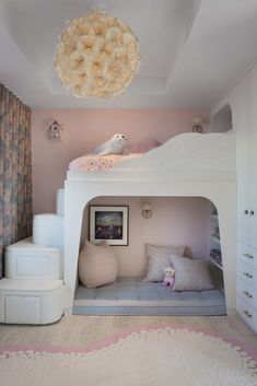 a white bunk bed sitting in a bedroom next to a pink wall and ceiling light