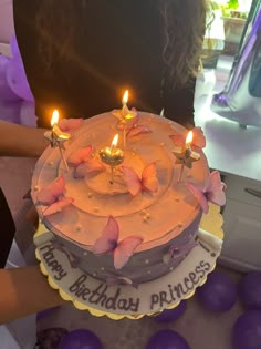 a birthday cake with three lit candles on it