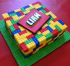 a cake made out of legos sitting on top of a red tableclothed surface