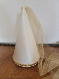 "This is a new Princess Cone hat. The hat is made with beautiful cream/ off white/ pearl/ ivory colored satin  stretched over a cardboard frame, so it holds its shape very well. It is trimmed with beautiful gold braid or sequins and has a veil made with gold tulle.  It has an adjustable elastic to hold it in place Available in three sizes.    Small is approximately 9-1/2\" tall with a 17-1/2\" circumference around the base.   (suggested for toddlers age 1 to 3)  Medium is approximately 11-1/2\" Princess Cone Hat, Little Bo Peep Costume, Cone Hat, Gold Tulle, Ren Fair, Cardboard Frame, Little Bo Peep, Toddler Age, Halloween Photos