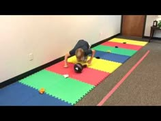 a man is doing push ups on foam mats in an office hallway with balls and toys