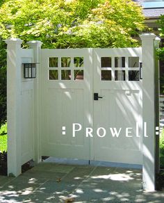 a white gate with the word prowl written on it in front of some trees