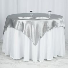 a round table with two silver plates on it